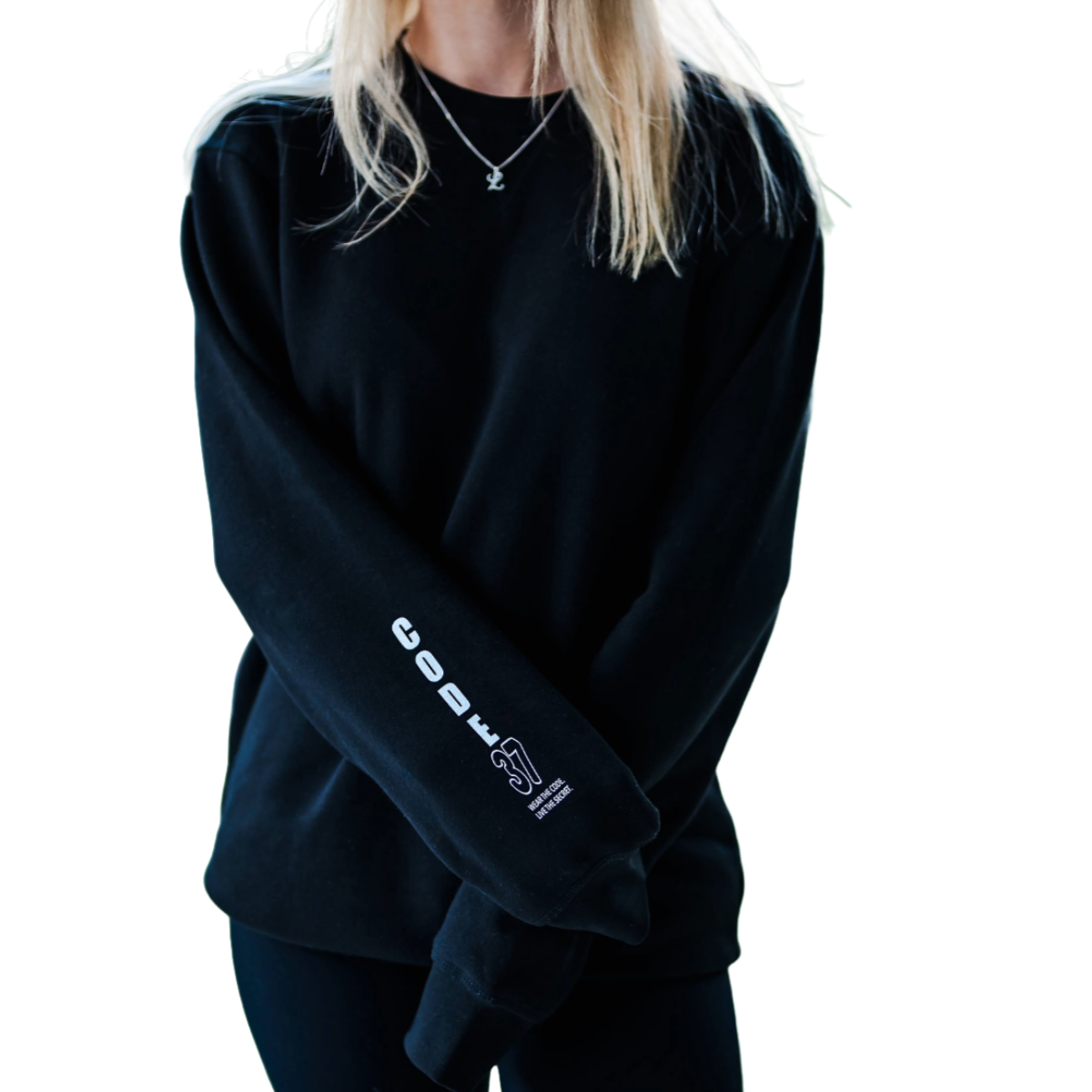 Person wearing a black sweatshirt with a logo on the sleeve against a white background