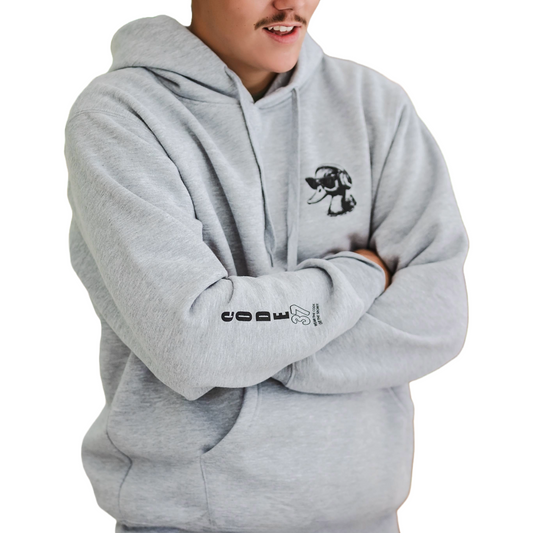 Person wearing a gray hoodie with a logo on the chest and text on the sleeve, against a white background