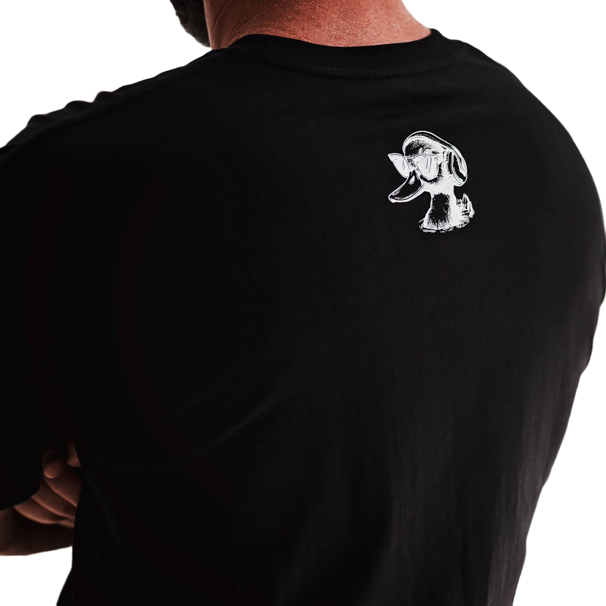Black t-shirt with a white logo on the back, worn by a person.