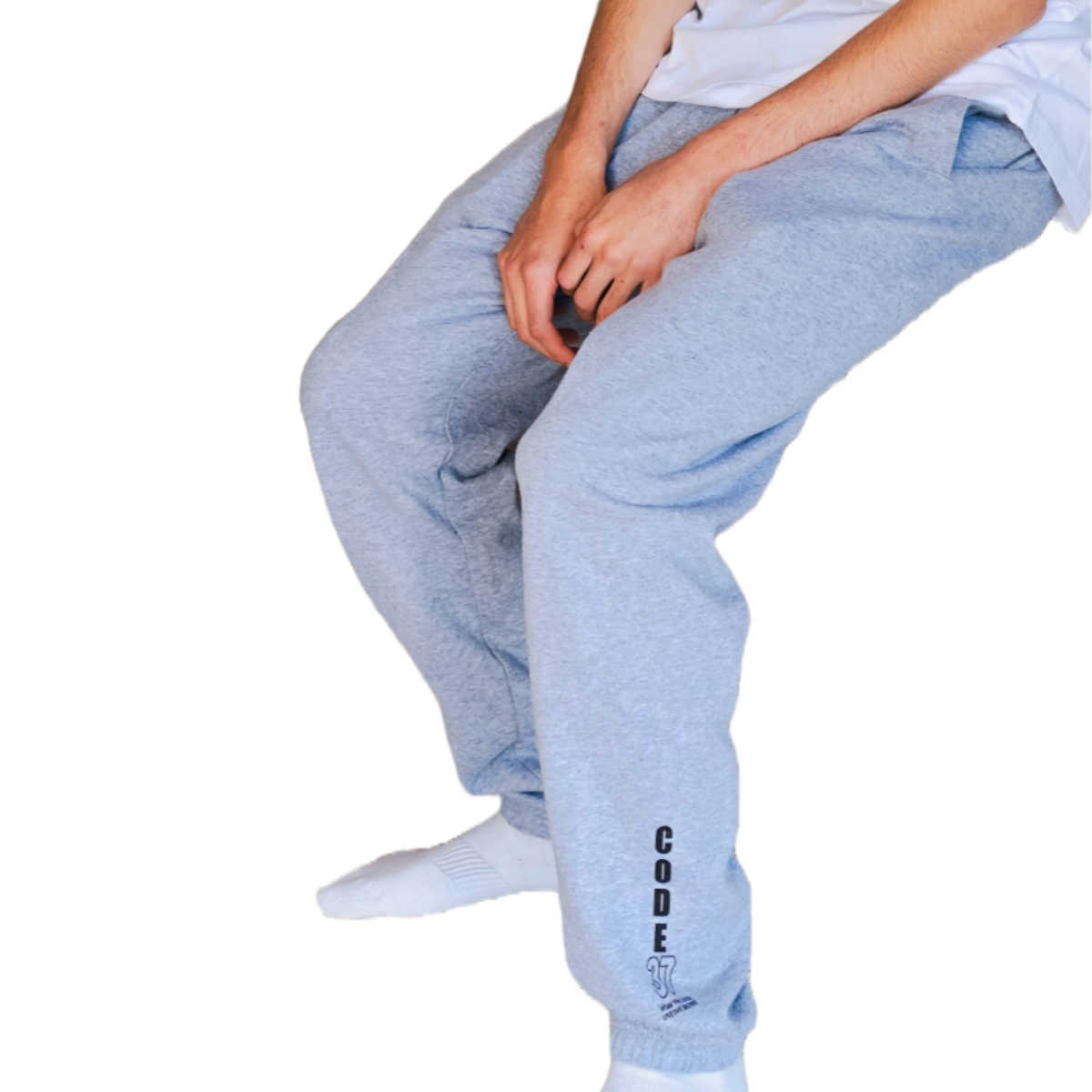 Person wearing grey jogger pants and a white t-shirt on a white background